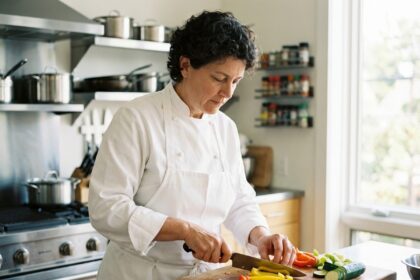 Chef femme coupant des légumes dans une cuisine moderne