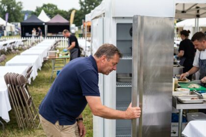Homme inspectant un frigo lors d'un festival en plein air