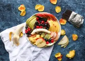 bowl of sliced fruits on white textile